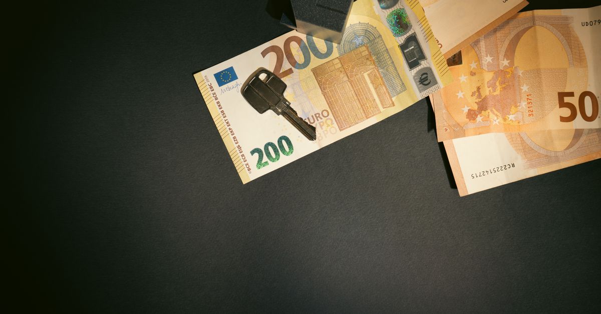 Flat lay of a house key on Euro bills representing real estate investment and finance.